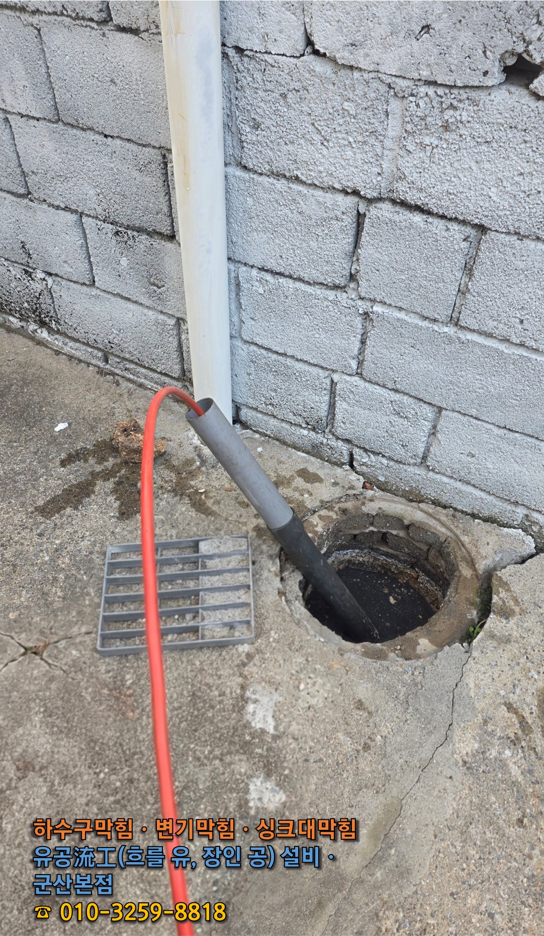 원형 맨홀 배관 입구로 고압세척 호스를 진입시켜 막힌 구간 타격을 준비하는 모습