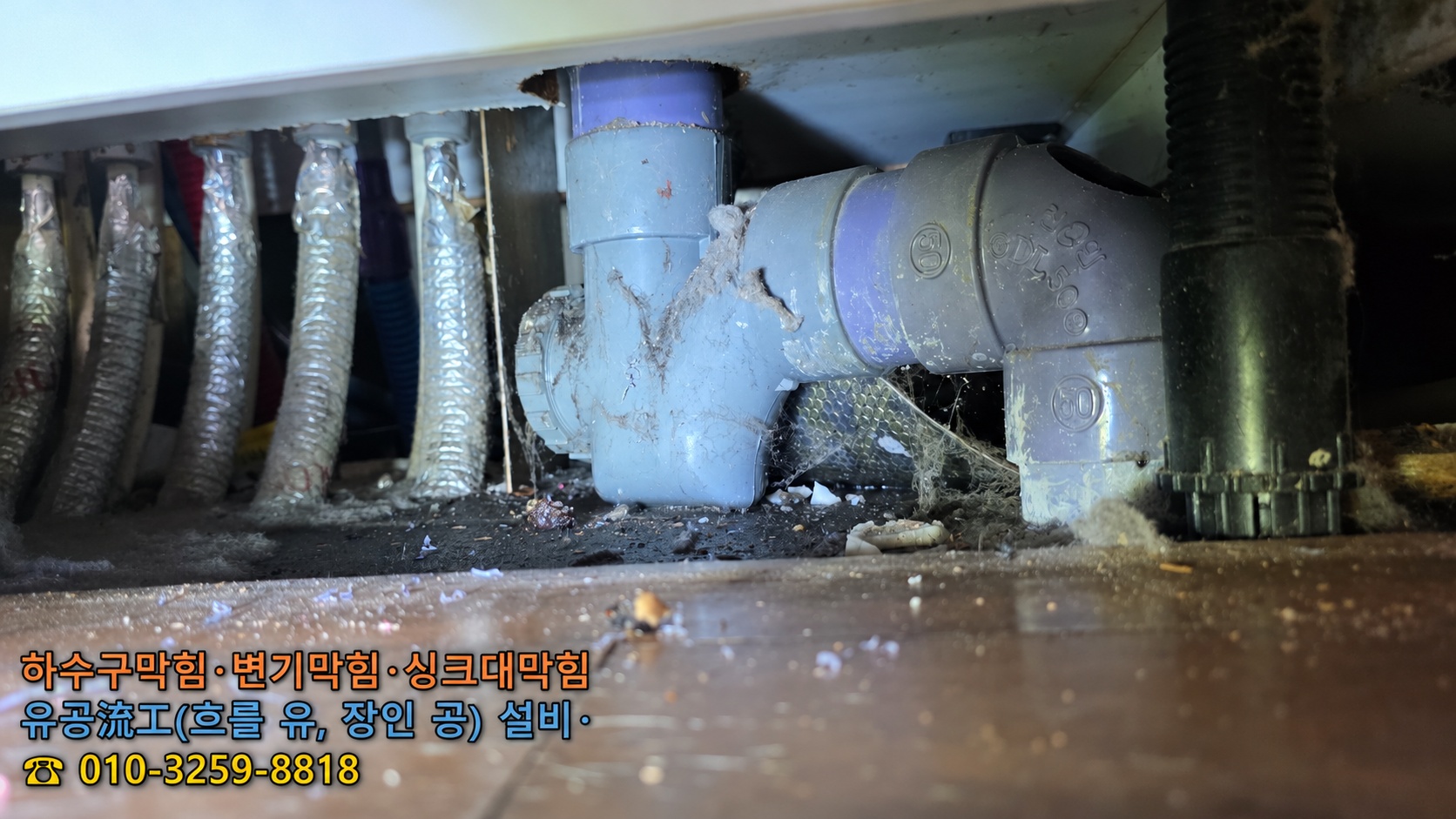 군산 지곡동 싱크대 아래쪽 배수 트랩과 연결 배관을 확인하는 장면 – 유공설비 군산본점